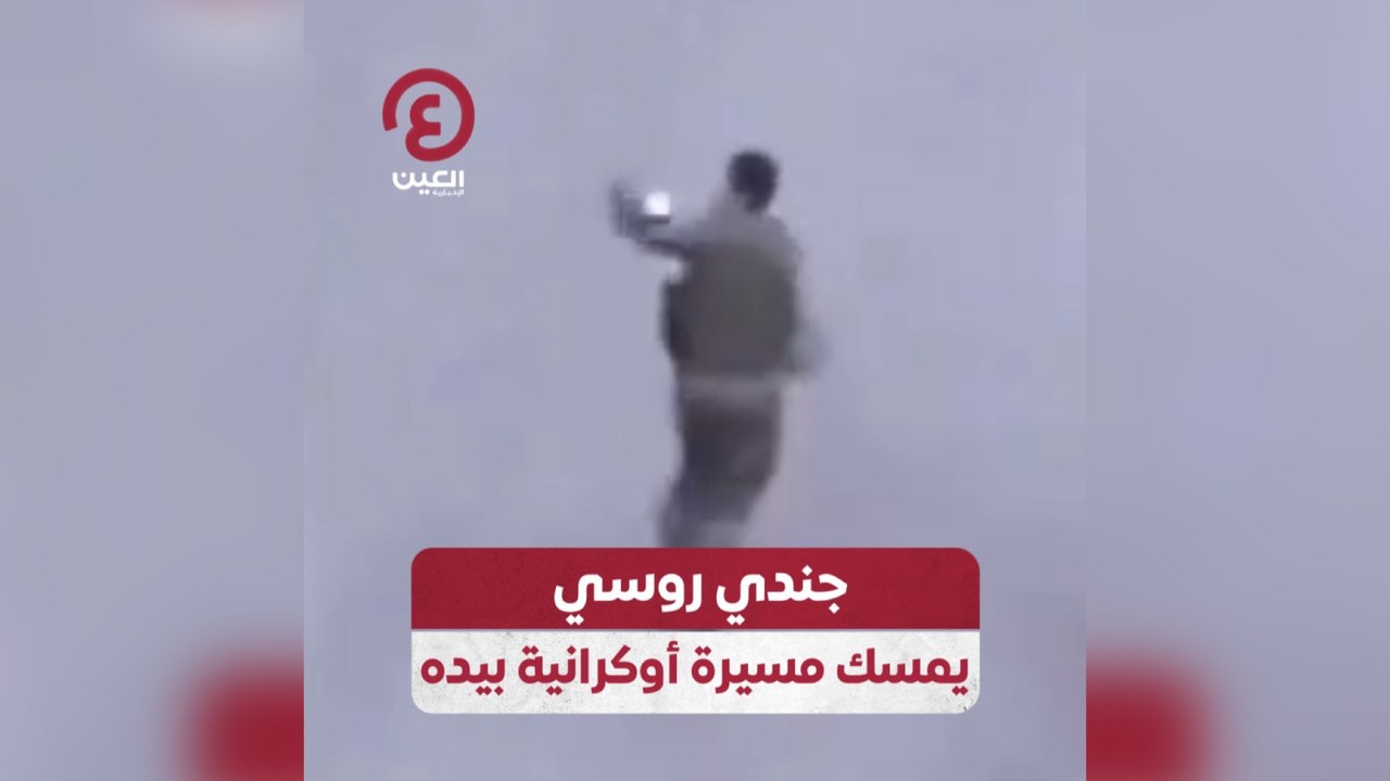 جندي روسي يمسك مسيرة أوكرانية بيده