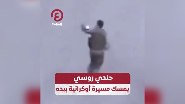 جندي روسي يمسك مسيرة أوكرانية بيده