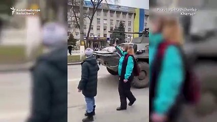 Los ucranianos ondean banderas en una protesta en la ciudad tomada por las fuerzas rusas