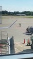 Un trabajador del aeropuerto muestra sus habilidades con el bastón en la pista de aterrizaje