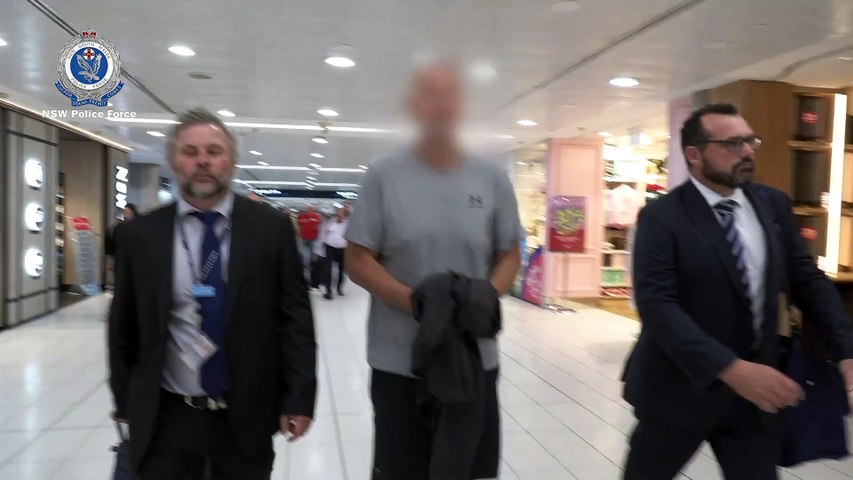 A man arrives with detectives in Sydney after his extradition from Queensland in relation to an alleged multi-million dollar fraud involving Southern Highlands companies. Video by NSW Police Force