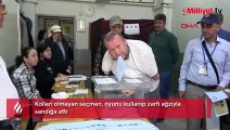 Kolları olmayan seçmen, oyunu kullanıp zarfı ağzıyla sandığa attı