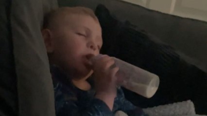 Dreamer's dilemma: Little drowsy child holds his ghostly milk feeder