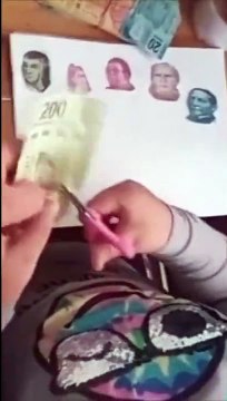 Niña pequeña recorta billetes para ilustrar su tarea