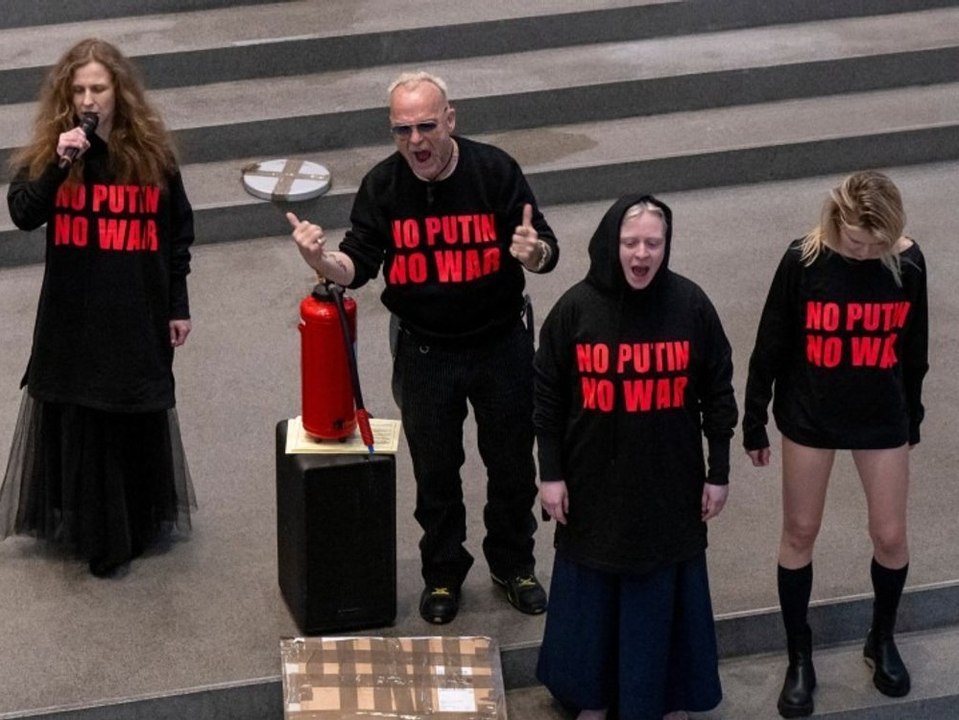 Drastischer protest: mitglied von pussy riot uriniert auf putin-bild