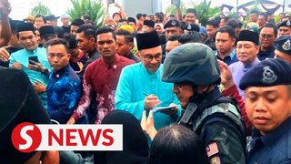 Anwar signs autographs, meets with visitors at Madani Raya event in Sabah