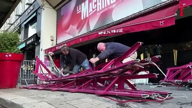 Broken sails from Moulin Rouge windmill in Paris removed from sidewalk