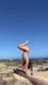 Woman Performs Handstand at Beach