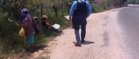 Policías hondureños ayudan con su carga a abuelitos