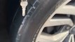 Keys Puncture Tire of Moving Car on Road