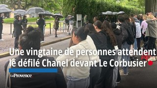 Des curieux attendent le défilé Chanel devant l’entrée de la Cité radieuse