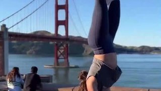 Woman Performs Handstand Near Bridge