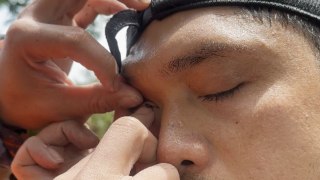 Hikers struggle to remove a leech from their friend's eye on rain-soaked Mt. Isarog