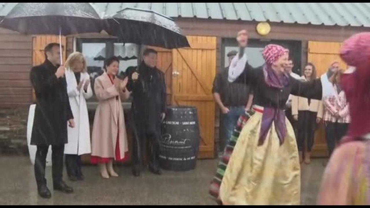 Xi e Macron assistono a una anza folkloristica sotto il diluvio