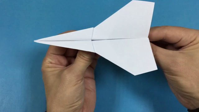 Un avion à grande vitesse en papier coloré qui vole loin