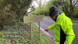 Father and son clean Ceredigion's village signs