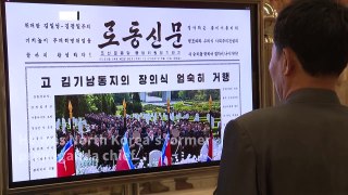 North Koreans read news on former propaganda chief's death