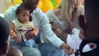 Rihanna tries to hold her son, Rza, during his birthday party