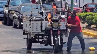 Sujeto que apaga el incendio de una motocicleta con una Coca-Cola