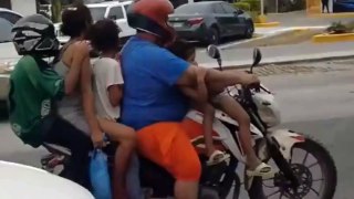 Familia de seis personas viajando en una motocicleta en La Ceiba