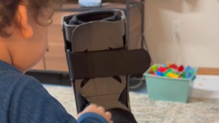 Supersized steps: Tiny hero takes on the world in his dad's giant medical boot