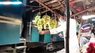 Fruit vendor protecting his grapes from train passengers in Bangladesh