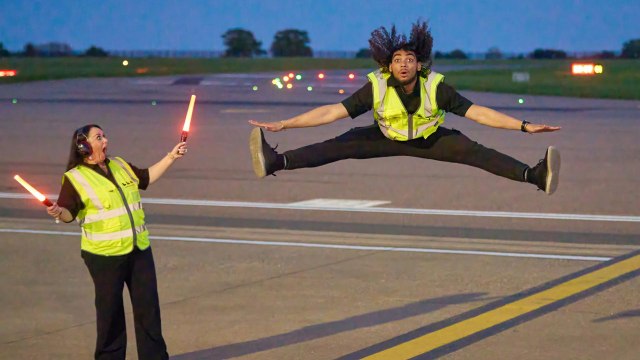 Ground handlers perform dance routine with aircraft marshalling wands