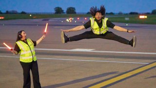 Ground handlers perform dance routine with aircraft marshalling wands