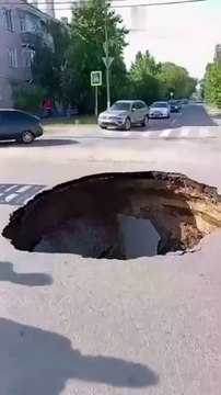 Des voitures évitent le pire quand la route s'ouvre devant eux...