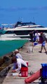 c10M Ferretti Yacht passing the Haulover Inlet jetty and beach in Bal Harbour, Florida