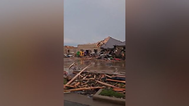 Debris scattered around damaged buildings after tornados rip through Texas city