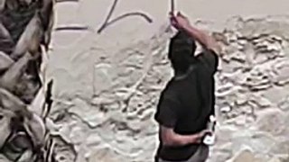 Un hombre pinta un grafiti en el Raval