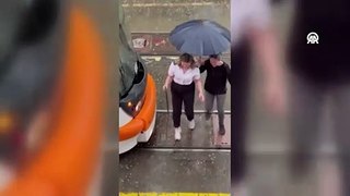 Kadın esnaf vatmanın ıslanmaması için şemsiye tuttu