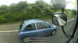 Woman applies make-up while driving along the motorway