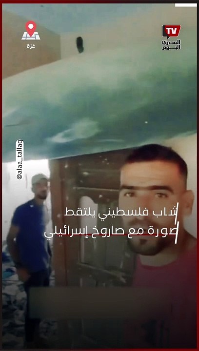 شاب فلسطيني يلتقط صورة مع صاروخ إسرائيلي اخترق منزله ولم ينفجر