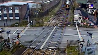 Pedestrian seconds away from being hit by train after climbing barrier at railway crossing