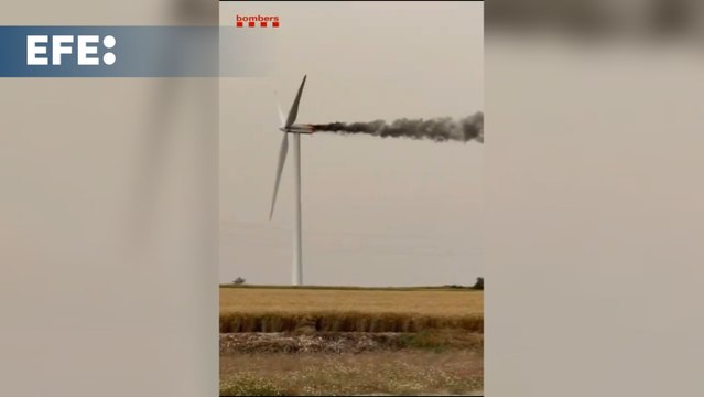 Los bomberos tratan de apagar desde un helicóptero un incendio en un aerogenerador en Pujalt (Barcelona)