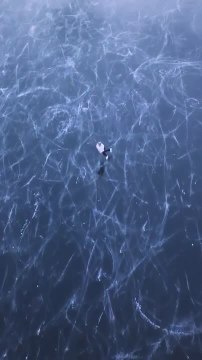 Ice Skater Looks Magical on Frozen Lake Surrounded by Swiss Alps in Switzerland
