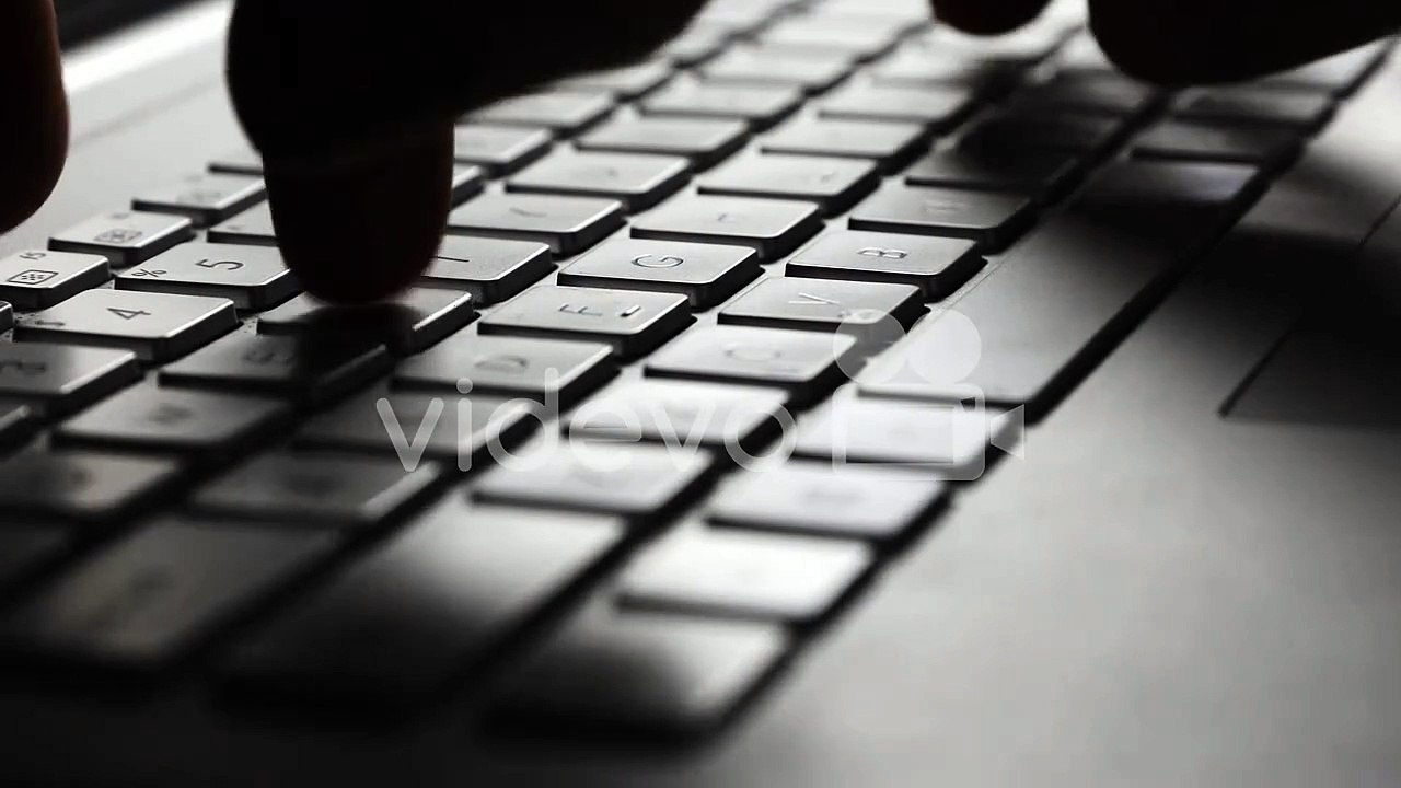 closeup of fingers typing on laptop computer keyboard