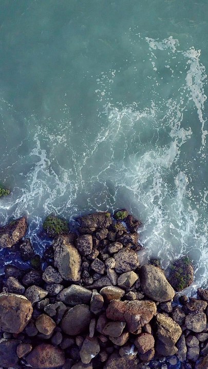 mixkit-overhead-view-of-a-rocky-coast-and-waves-crashing-51502-full-hd