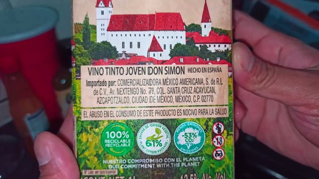 Abriendo una caja de vino tinto don simon acostado en la cama descansando y enviando saludos a todos