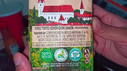 Abriendo una caja de vino tinto don simon acostado en la cama descansando y enviando saludos a todos