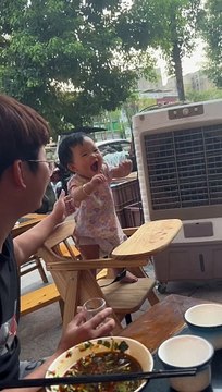 Cute baby - bayi lucu berusia 7 bulan itu berdiri sendiri di kursi bayi dan dicengkeram lehernya oleh ayahnya