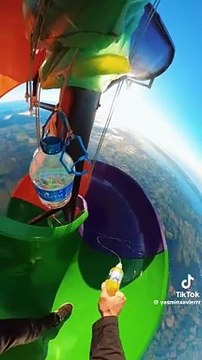 Due ragazzi si gettano da uno scivolo sospeso attaccato ad una mongolfiera