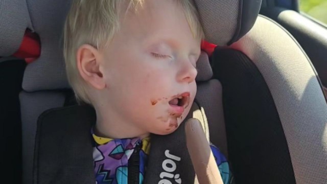 Little boy struggles to eat an ice cream after a day at the beach