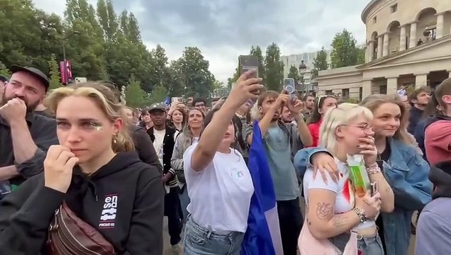 El momento en que los franceses concentrados en París para seguir los resultados electorales han conocido las proyecciones de la televisión estatal francesa que dan como vencedor al Nuevo Frente Popular