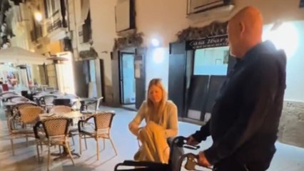Playful dad makes the family laugh by moving mom's wheelchair away repeatedly