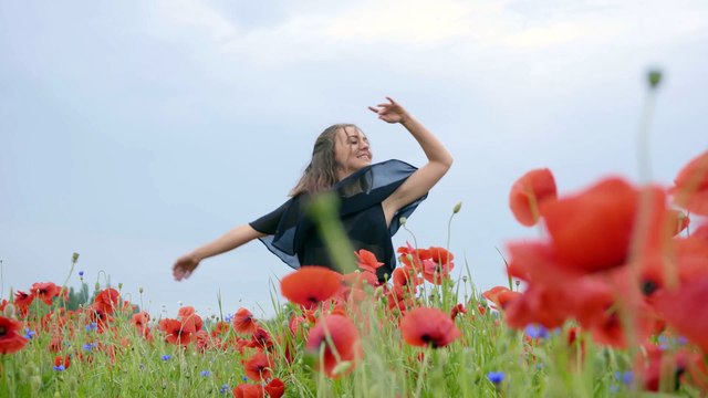 mixkit-girl-dancing-happily-in-a-field-of-flowers-4702-4k