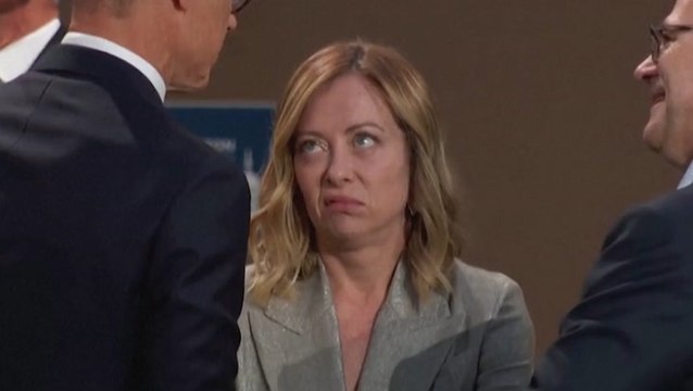 Italian prime minister looks at imaginary wristwatch while waiting for Biden at Nato summit