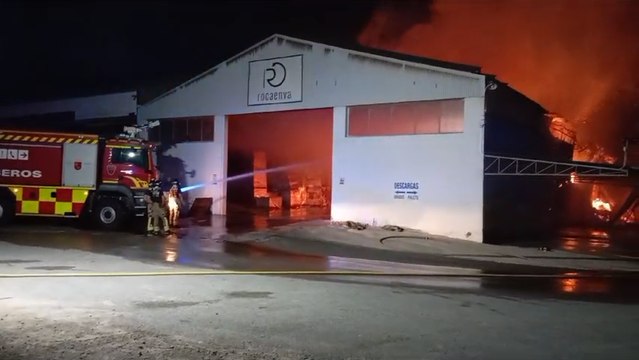 Los bomberos trabajando durante la madrugada del martes en el incendio declarado en la empresa de palets de Las Torres de Cotillas.